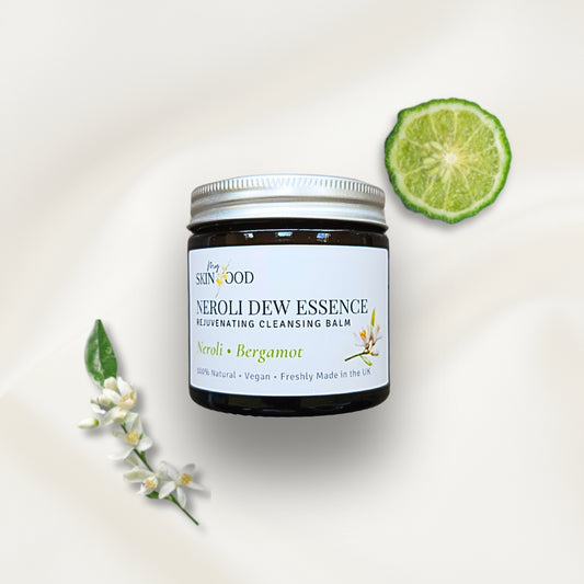 Jar of My Skinfood Neroli Dew Essence cleansing balm with a lime wedge and flowers on a light background