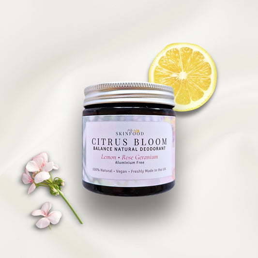 Skinfood Citrus Bloom natural deodorant jar with a lemon slice and flowers on a light background