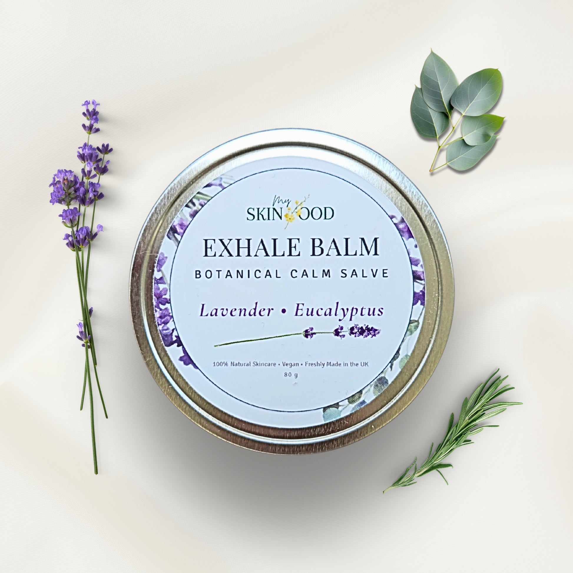 My Skinfood Exhale balm salve container with lavender and eucalyptus leaves on a white background